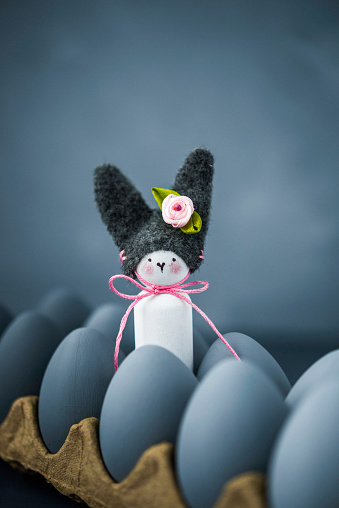 Dark toned Easter still life with hand painted ombre eggs and cute handmade Easter bunny.