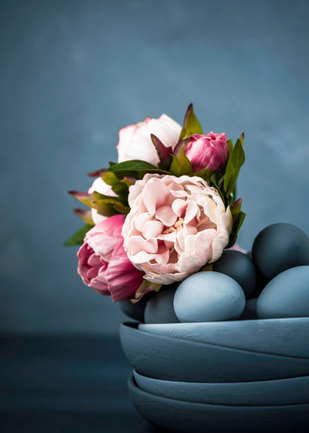 Dark toned Easter still life with hand painted ombre eggs and bowls, and peony bouquet. Eggs and props painted by photographer.