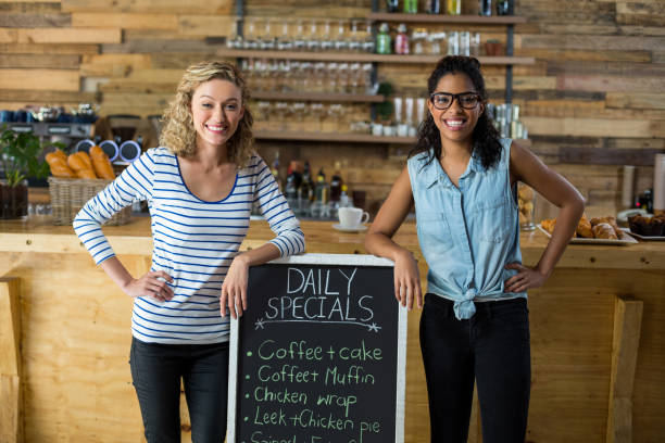 istock Two female friends standing with menu signboard at counter 657327582