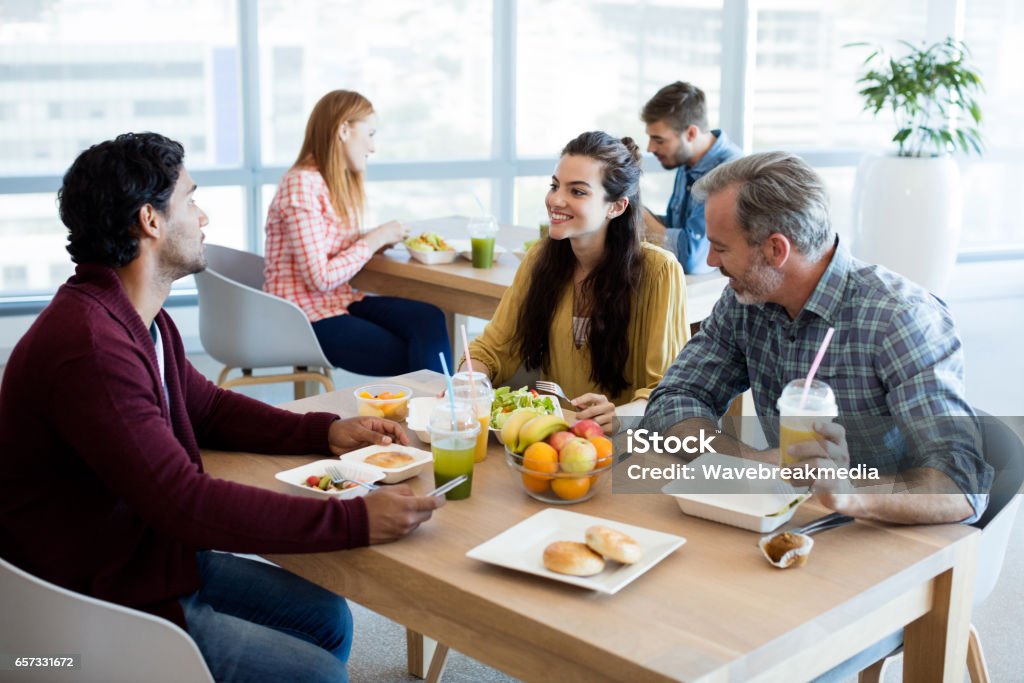 Equipe de negócios criativos discutindo, tendo a refeição - Foto de stock de Cantina royalty-free