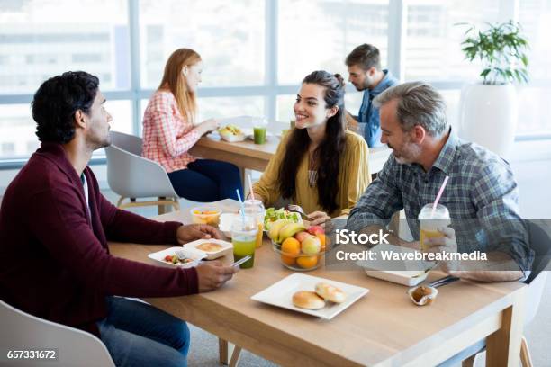 Foto de Equipe De Negócios Criativos Discutindo Tendo A Refeição e mais fotos de stock de Cantina