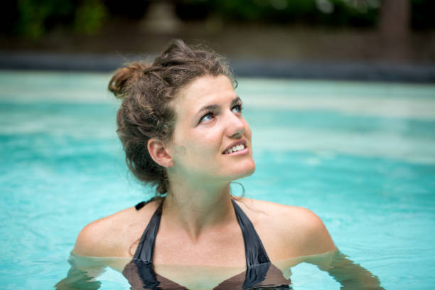 istock Smiling Young Woman Swimming in Pool 657336218