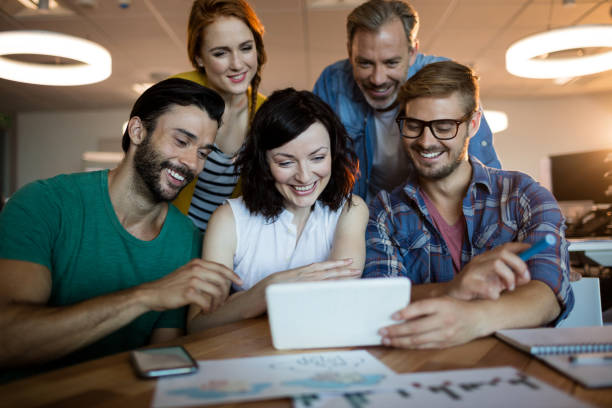 istock Happy creative business team discussing over digital tablet 657347100