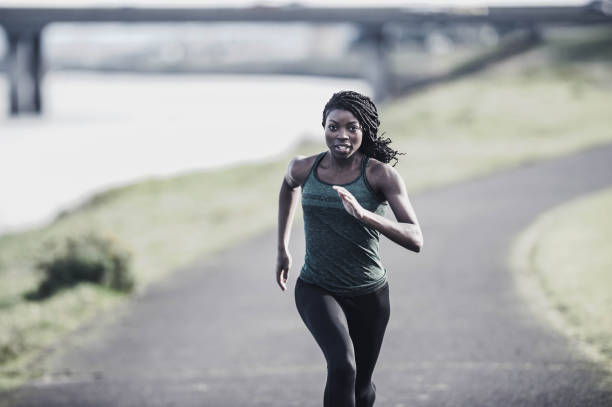istock African American woman training and jogging by river 657351686