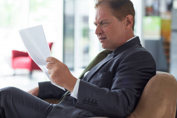 istock Displeased senior businessman reading document 657360540