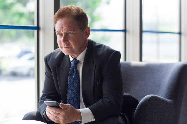 istock Serious senior businessman with phone in lobby 657360620
