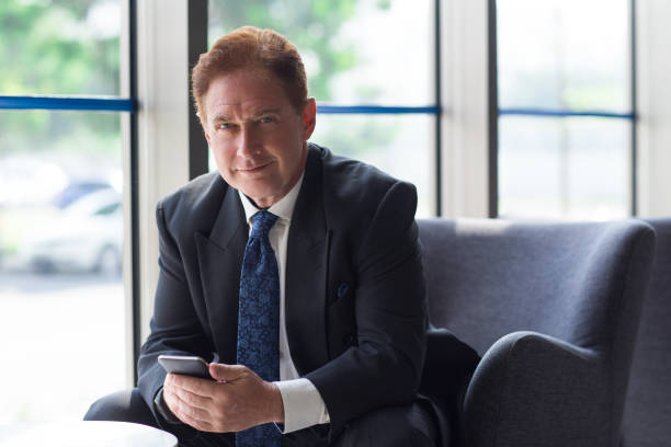 istock Smiling senior businessman sitting in lobby 657360674