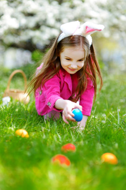 istock Adorable little girl hunting for easter egg in blooming spring garden 657367202