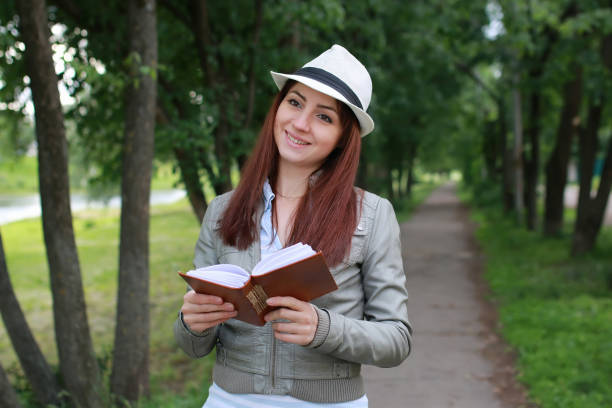 istock girl with book in park 657369394