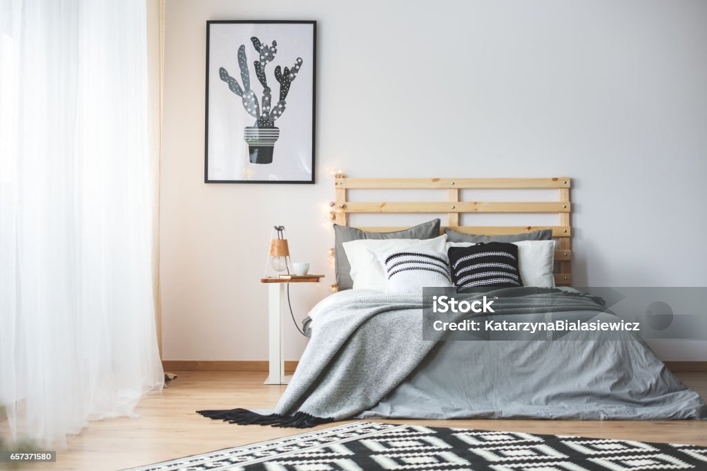 Black and white bedroom Black and white bedroom with grey accessories, big window and cactus poster Bedroom Stock Photo