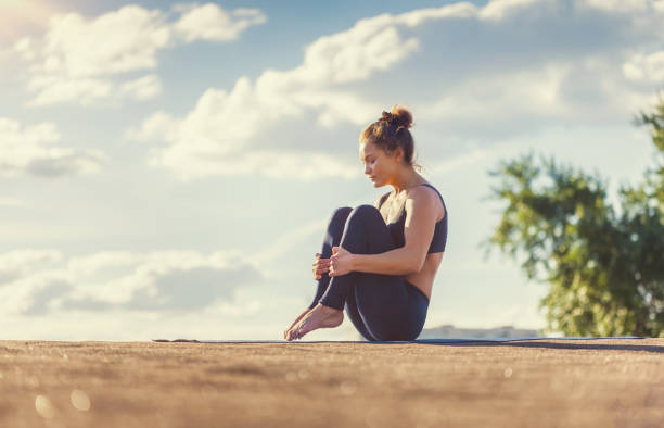 istock Young woman doing yoga exercises at sunset 657372004