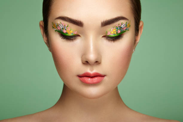 istock Young beautiful woman with flower makeup eyes 657372274