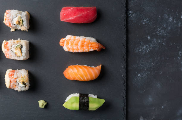 istock Various sushi and rolls with wasabi on slate plate and black stone table. Free space and top view 657377272