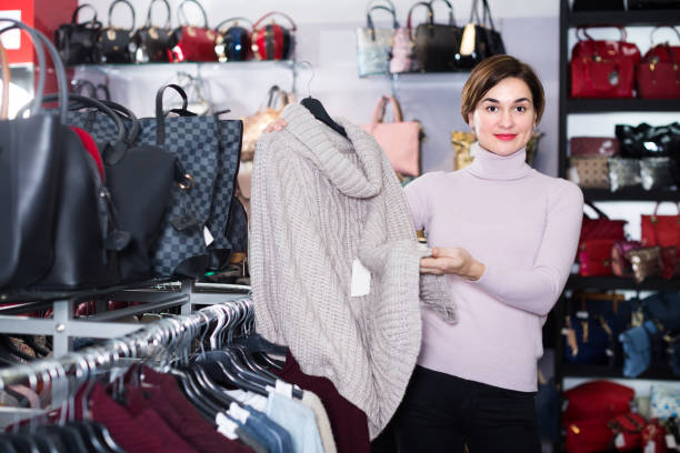 istock Young female customer is deciding on warm sweater 657378094