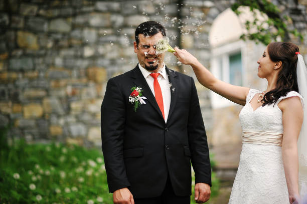 istock wedding couple blowing on a dandelion 657392664