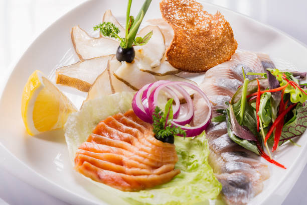 istock Restaurant plate of various fish with herbs, lemon and onion. Selective focus 657396598