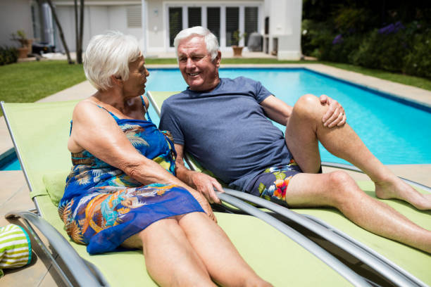 istock Senior couple interacting with each other on lounge chair 657401216
