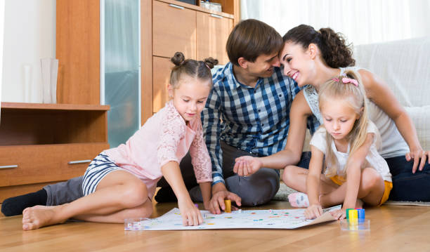 istock girls playing with parents at board game on floor 657404704