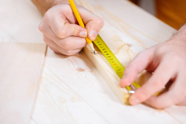 istock partial view of carpenter taking measures of wooden plank 657407486