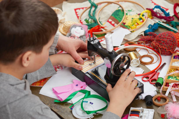 istock boy tailor learns to sew, job training, handmade and handicraft concept 657408276