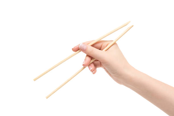 istock Isolated female hand holds chopsticks on a white background. 657409112