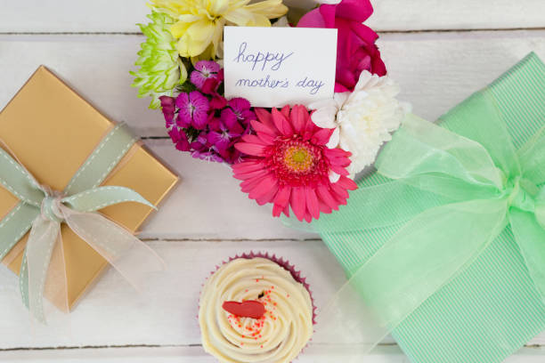 istock Cup cake, gift box and fresh flowers on wooden surface 657421146