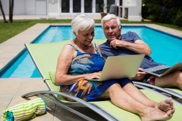 istock Senior couple using laptop on lounge chair 657421338