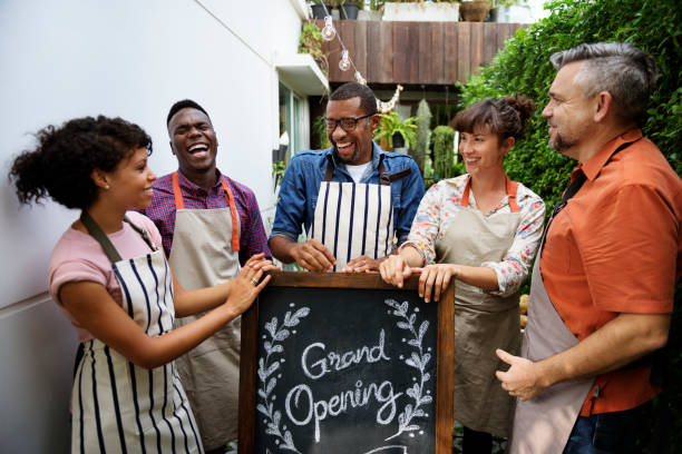 Group of friends with grand opening board together