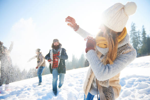 Young smiling couple playing in snowy woods