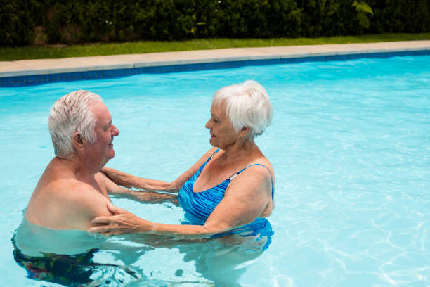 istock Senior couple embracing each other in the pool 657424548