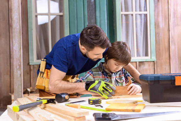 istock portrait of father teaching son how to use hand plane in workshop 657424618