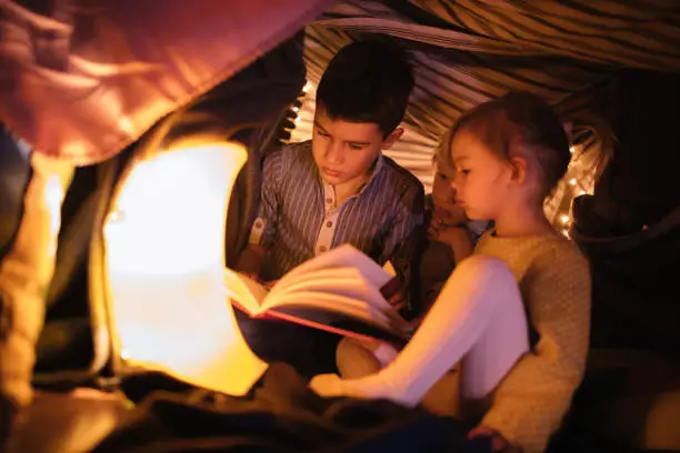 Photo of Children in a fort listening to a night story