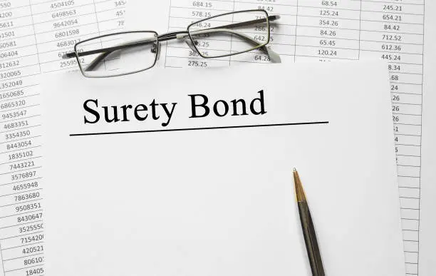 Photo of Paper with Surety Bond on a table