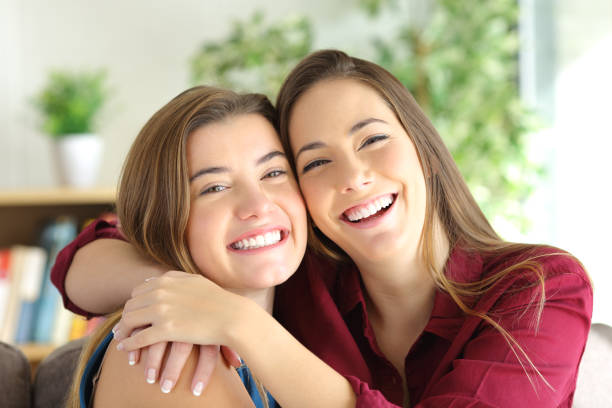 freunde oder geschwister lächeln und posieren - dental cosmetic stock-fotos und bilder