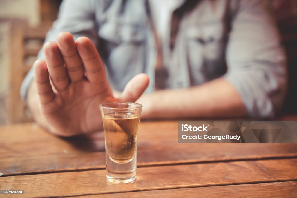 Guy at the pub Cropped image of man showing stop gesture and refusing to drink Alcohol Abuse Stock Photo