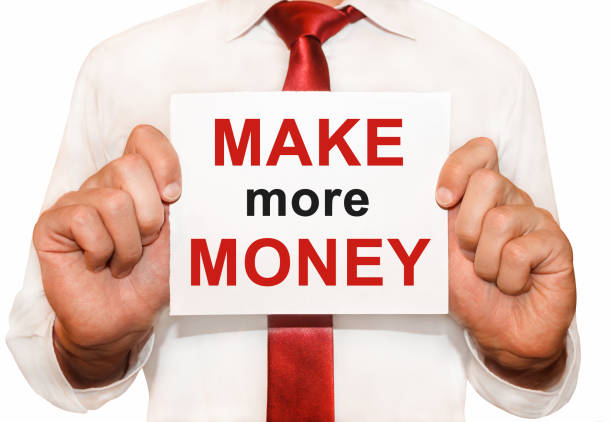 istock Man holding a card with a text Make More Money. 657428434