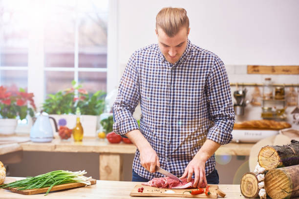 istock Handsome man cooking at home preparing meat stake from pork or beef or lamb 657428898