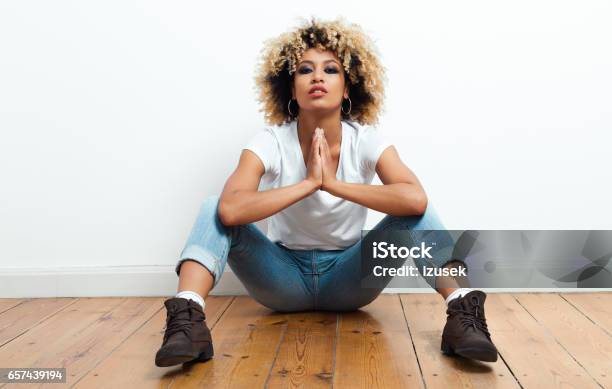 Confident Afro American Young Woman Sitting On The Floor Stock Photo - Download Image Now