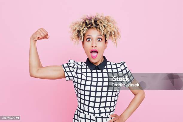 Excited Afro American Young Woman Flexing Muscle Stock Photo - Download Image Now - Bicep, Flexing Muscles, Only Women