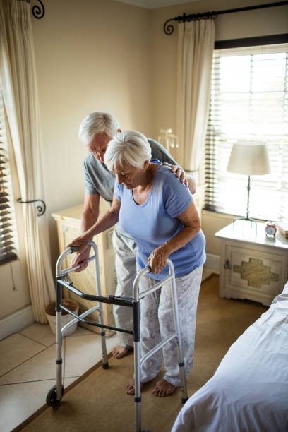 istock Senior man helping woman to walk with a walker 657442540