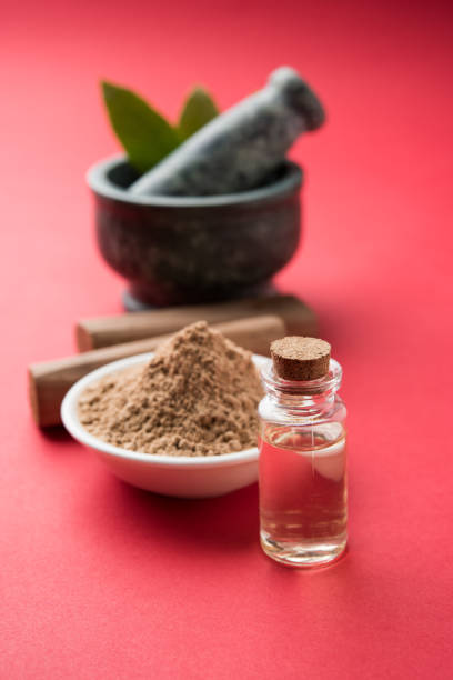 chandan or sandalwood powder with traditional mortar, sandalwood sticks, perfume or oil and green leaves. selective focus - cold tint imagens e fotografias de stock