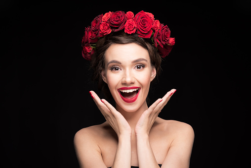 smiling woman with roses wreath on head looking to camera