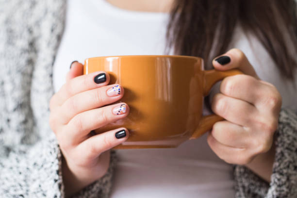 istock A young pregnant woman holding a cup, close-up 657449000