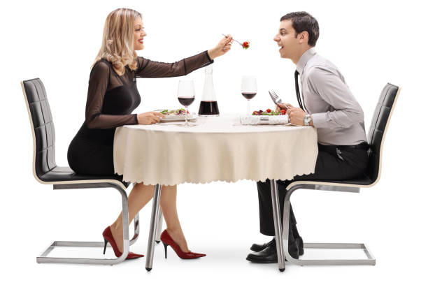 istock Young woman feeding her boyfriend salad at restaurant table 657449016