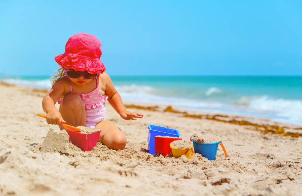istock cute little girl play with sand on beach 657457108