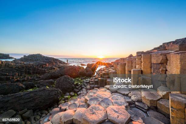 Tourist At Sunset Over Giants Causeway Northern Ireland Stock Photo - Download Image Now