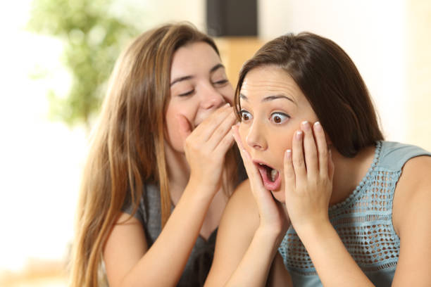 istock Girl telling secrets to her amazed friend 657465062