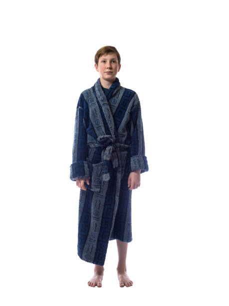 Young boy with a sleepy look and a blue bathrobe on a white background