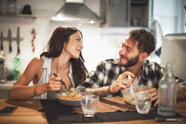 istock Young couple eating together at home 657474356