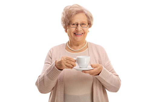 Cheerful elderly woman holding a cup isolated on white background